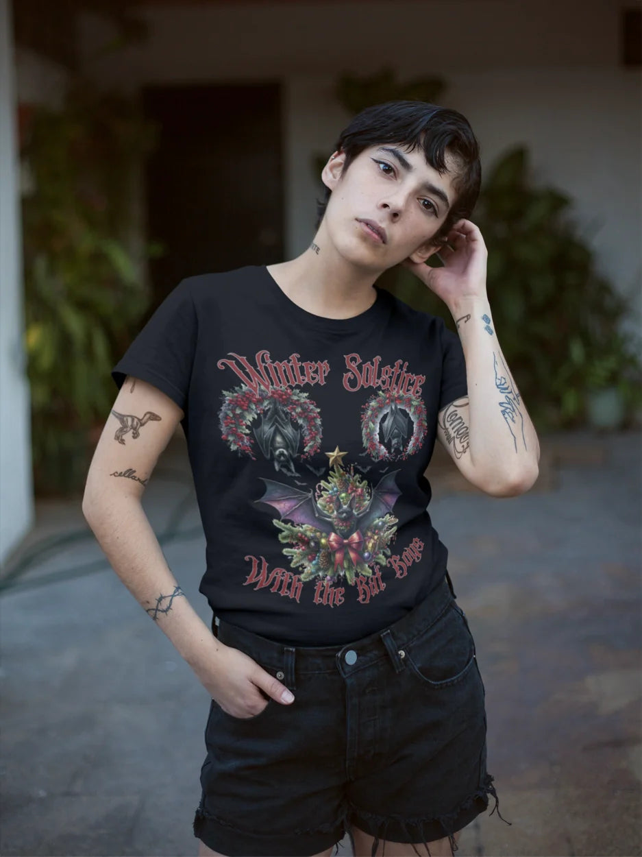 Person wearing a black t-shirt with a graphic design, standing outdoors.
